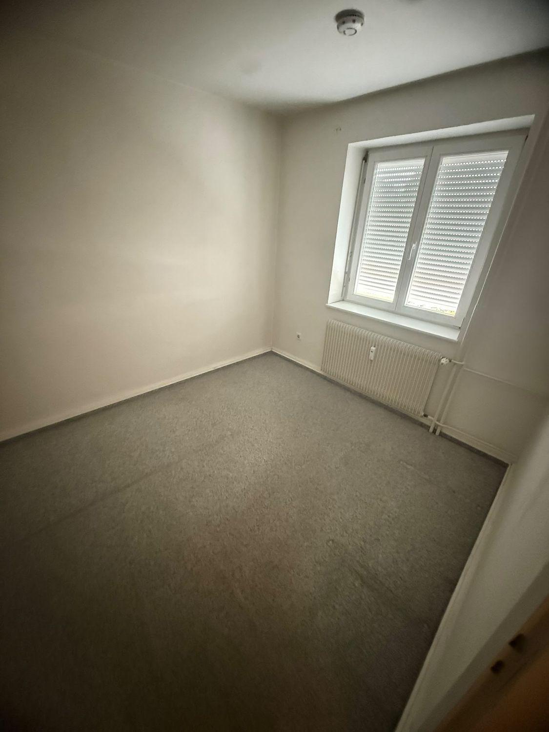 Leer geräumtes kleines Zimmer mit Teppichboden